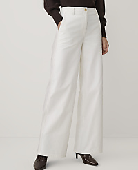 A person wearing a brown sweater, wide-leg white trousers, and dark brown heels stands against a plain, light-colored background. carousel Product Image 2
