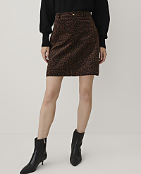 A person wearing a black sweater, a leopard-print mini skirt, and black ankle boots stands against a plain white background. carousel Product Image 2