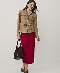 A woman wearing a tan belted jacket and a long red skirt stands against a plain white background. carousel Product Image 4