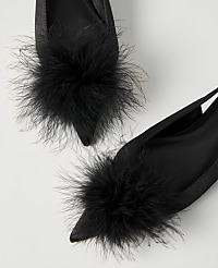 Two black satin pointed-toe shoes with fluffy black feather pom-poms are set against a plain white background. carousel Product Image 2