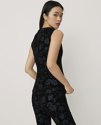 A woman wearing a black floral velvet two-piece set poses against a plain, light-colored background. carousel Product Image 2