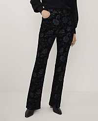 A person wearing a black sweater and floral-patterned black velvet trousers stands against a plain white background. carousel Product Image 2