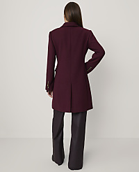 A woman stands with her back to the camera wearing a burgundy coat and dark wide-leg trousers against a plain light grey background. carousel Product Image 2