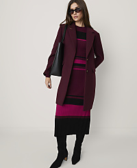 A woman wearing a burgundy coat, a striped knit dress, and black boots stands against a plain light-colored background. carousel Product Image 3