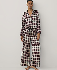 A woman wearing burgundy and white checkered pajamas stands against a plain white background. carousel Product Image 1