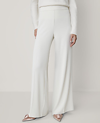 A person wearing a white sweater, wide-leg white trousers, and pointed pink heels stands against a plain, light-colored background. carousel Product Image 2