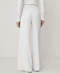 A person wearing a white sweater and wide-leg white trousers stands against a plain, light-colored background. carousel Product Image 3