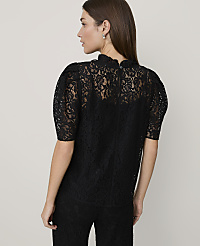 A woman wearing a black lace top and matching pants stands against a plain, light-colored background. carousel Product Image 2