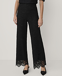 A person wears black lace wide-leg trousers and pointed heels against a plain light grey background. carousel Product Image 2