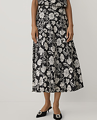 A person wears a black and white floral print midi dress and black pointed-toe heels against a plain white background. carousel Product Image 2