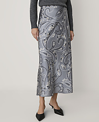 A person wearing a grey sweater, a grey paisley-print midi skirt, and black pointed-toe heels stands against a plain white background. carousel Product Image 2