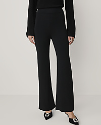 A person wearing a black sweater, black wide-leg trousers, and black pointed heels with buckles stands against a plain light gray background. carousel Product Image 2