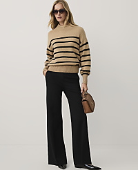 A woman wearing a tan striped sweater, black wide-leg trousers, and sunglasses stands against a plain white background. carousel Product Image 1