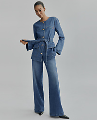 A woman wearing a blue denim belted jacket and matching wide-leg pants stands against a plain light gray background. carousel Product Image 4