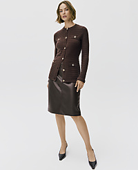 A woman wearing a brown buttoned cardigan and a dark brown leather skirt stands against a plain white background. carousel Product Image 5