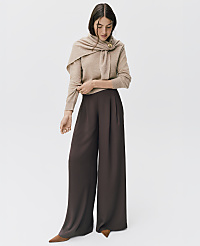 A woman wearing a beige sweater with a matching scarf and wide-leg brown trousers stands against a plain white background. carousel Product Image 4