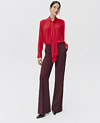 A woman wearing a red pussy-bow blouse and wide-leg burgundy trousers stands against a plain white background. carousel Product Image 5