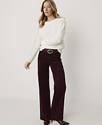 A woman wearing a white textured sweater and wide-leg burgundy corduroy pants stands against a plain white background. carousel Product Image 3