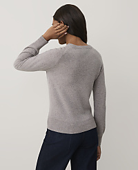 A woman wearing a grey sweater and dark blue jeans stands with her back to the camera against a plain white background. carousel Product Image 2