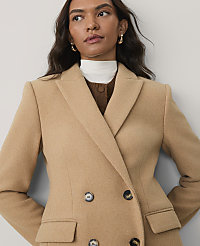 A woman wearing a tan double-breasted blazer over a brown and white layered top poses against a plain light gray background. carousel Product Image 3