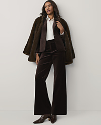 A woman wearing a brown faux-fur coat, blazer, and wide-leg velvet trousers stands against a plain white background. carousel Product Image 1