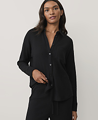 A woman wearing a black ribbed pajama set stands against a plain, light-colored background. carousel Product Image 1
