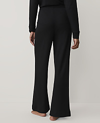 A person stands with their back to the camera wearing black ribbed wide-leg pants and a matching top against a plain light grey background. carousel Product Image 2