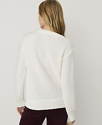 A woman wearing a white textured sweater and maroon corduroy pants stands against a plain light gray background. carousel Product Image 2