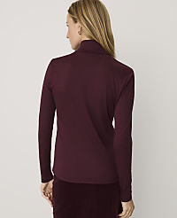 A woman wearing a burgundy long-sleeved turtleneck and matching corduroy pants stands against a plain white background. carousel Product Image 2