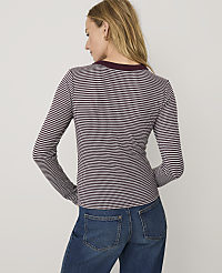 A woman wearing a maroon and white checkered long-sleeve shirt and blue jeans stands against a plain white background. carousel Product Image 2