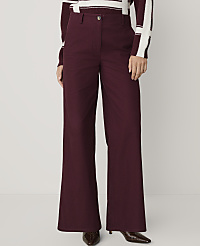 A person wears wide-leg burgundy trousers and a striped sweater against a plain, light-colored background. carousel Product Image 2