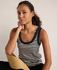 A woman in a striped tank top rests her chin on her hand while leaning against a curved wooden piece against a plain, light-colored background. carousel Product Image 1