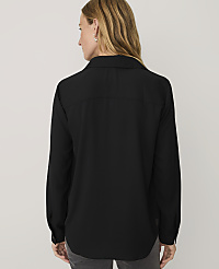 A woman wearing a black long-sleeved button-down shirt stands with her back to the camera against a plain light gray background. carousel Product Image 2