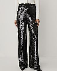 A person wears shimmering black sequined wide-leg trousers and a white top against a plain, light-colored background. carousel Product Image 2