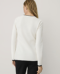 A woman wearing a white long-sleeved top and black trousers stands with her back to the camera against a plain light gray background. carousel Product Image 2