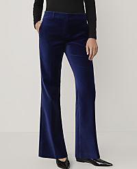A person wears royal blue velvet flared trousers and a black top against a plain light grey background. carousel Product Image 2
