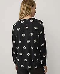 A woman wearing a black floral print blouse and black pants stands against a plain white background. carousel Product Image 2