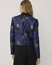 A woman stands with her back to the camera wearing a blue floral jacquard blazer and black trousers against a plain light gray background. carousel Product Image 2