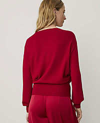 A woman wearing a red sweater and matching red pants stands against a plain, light-colored background. carousel Product Image 2