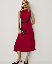 A woman wearing a red midi dress and black heels stands against a plain white background. carousel Product Image 3