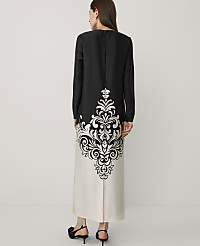 A woman stands with her back to the camera wearing a long black and white gown with a large ornate pattern, set against a plain white background. carousel Product Image 2