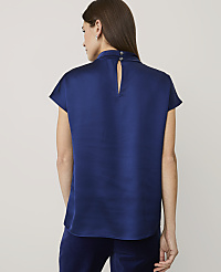 A woman stands with her back to the camera wearing a royal blue satin top and dark trousers against a plain light gray background. carousel Product Image 2