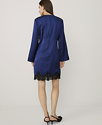 A woman wearing a royal blue dress with black lace trim and black heels stands against a plain white background. carousel Product Image 2