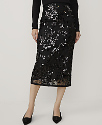 A person wears a black sequined midi skirt, a black long-sleeved top, and black pointed-toe heels against a plain white background. carousel Product Image 2