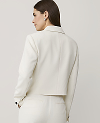 A woman wearing a white blazer and matching trousers stands against a plain, light-grey background. carousel Product Image 2