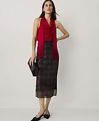 A woman wearing a red top and a black plaid skirt stands against a plain white background. carousel Product Image 2
