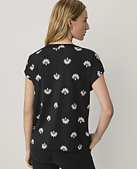 A woman wearing a black floral-print top and black pants stands against a plain white background. carousel Product Image 2