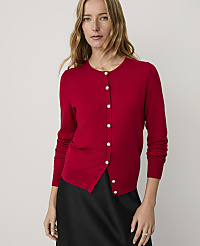 A woman wearing a red button-down cardigan and a black skirt stands against a plain, light-colored background. carousel Product Image 1
