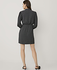 A woman stands with her back to the camera wearing a black and white polka dot dress and black heels against a plain white background. carousel Product Image 2