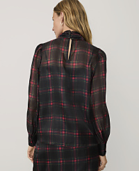 A woman wearing a black and red plaid blouse and matching skirt stands against a plain light gray background. carousel Product Image 2